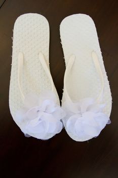 Simple white flip flop sandals for a bride to wear on her wedding day.