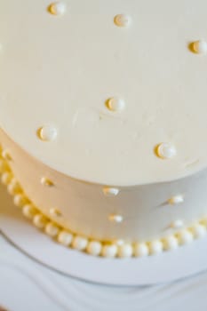 A very traditional white wedding cake at the reception for a bride and groom on their wedding day.