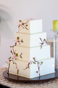 A very traditional white wedding cake at the reception for a bride and groom on their wedding day.