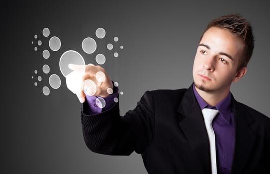 Businessman pressing high tech type of modern buttons on a virtual background