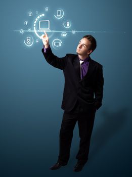 Businessman pressing multimedia type of modern buttons with virtual background