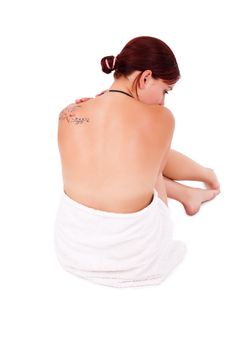 A worried and afraid young woman sitting on the flor, isolated on white