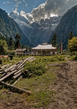 Tibetan house with mountains in the background which is the trail head for the hike to the Yubeng sacred waterfall in Meili mountain.