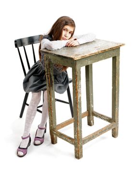 Sad Girl Sitting on Chair and Leaning on Big Table closeup on white background