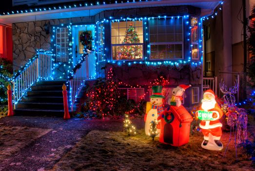 House Decorated with Christmas Lights and ornaments in front lawn