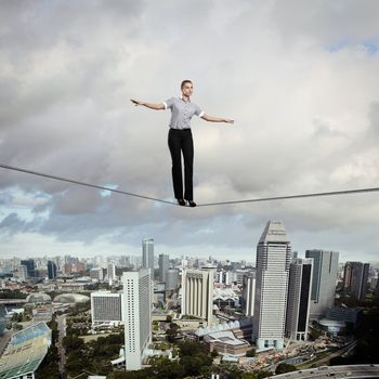 Business woman balancing high over a cityscape