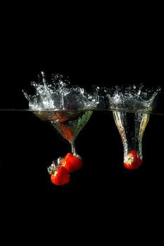 Colored red paprika in water splashes on black background