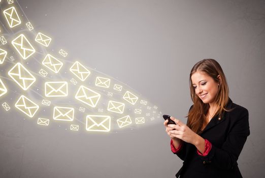 attractive young lady standing and holding a phone with message icons