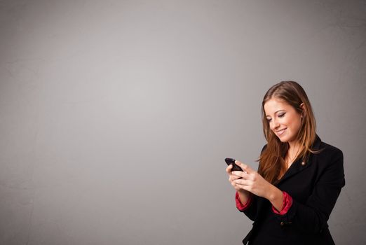 attractive young lady standing and holding a phone with copy space