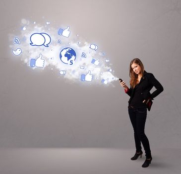 Pretty young girl holding a phone with social media icons in abstract cloud