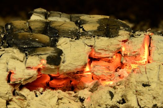 firewood coal and ashes burns down in a fireplace