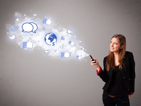 Pretty young girl holding a phone with social media icons in abstract cloud