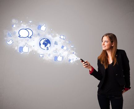 Pretty young girl holding a phone with social media icons in abstract cloud