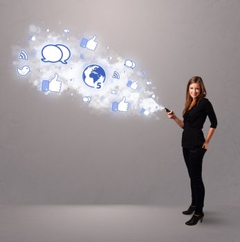 Pretty young girl holding a phone with social media icons in abstract cloud