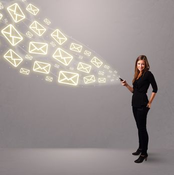 attractive young lady standing and holding a phone with message icons