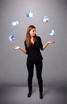 attractive young woman standing and juggling with social network icons