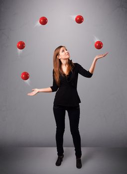 pretty young girl standing and juggling with red balls