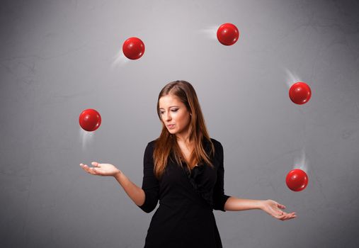 pretty young girl standing and juggling with red balls