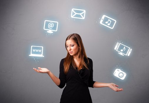 pretty girl standing and juggling with elecrtonic devices icons