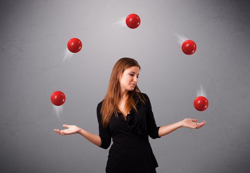 pretty young girl standing and juggling with red balls