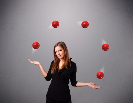 pretty young girl standing and juggling with red balls