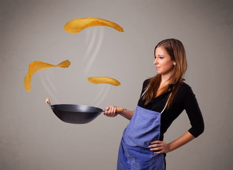 Beautiful young woman making pancakes