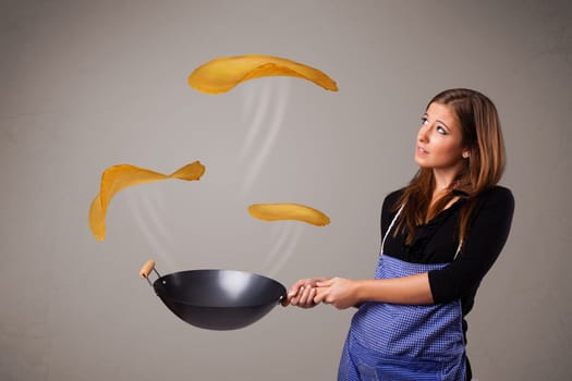 Beautiful young woman making pancakes