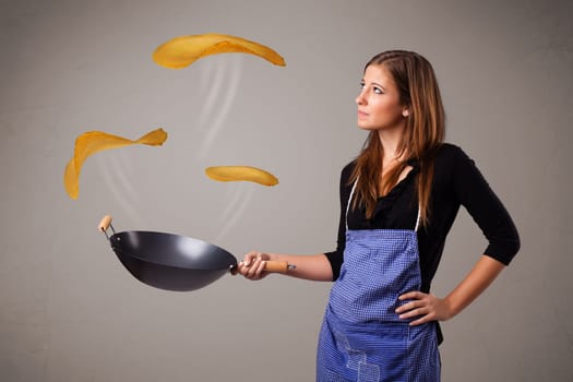 Beautiful young woman making pancakes