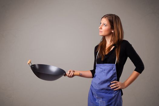 Attractive young lady holding a frying pan