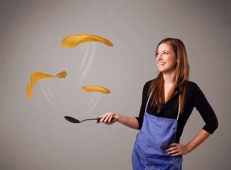 Beautiful young woman making pancakes