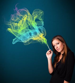 Pretty young lady smoking cigarette with colorful smoke