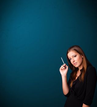 Beautiful young woman smoking cigarette with copy space