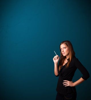 Beautiful young woman smoking cigarette with copy space
