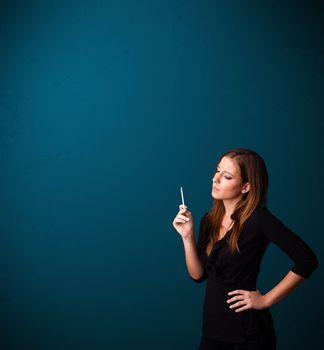 Beautiful young woman smoking cigarette with copy space