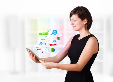 Young business woman looking at modern tablet with colourful technology icons