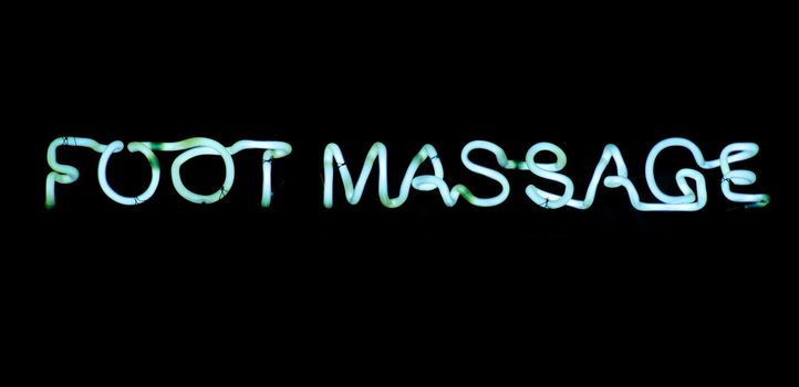 Foot massage blue  neon sign on black background