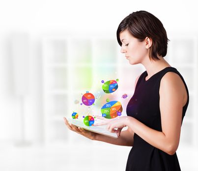 Young business woman looking at modern tablet with colourful pie charts