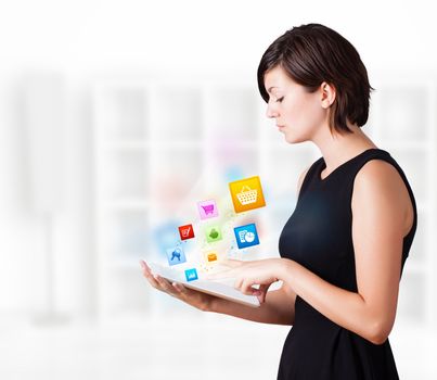 Young business woman looking at modern tablet with colourful icons