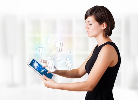 Young business woman looking at modern tablet with social icons