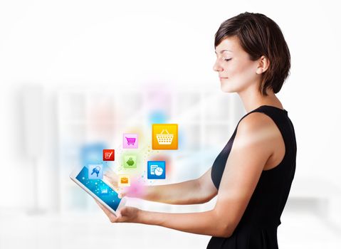 Young business woman looking at modern tablet with colourful icons