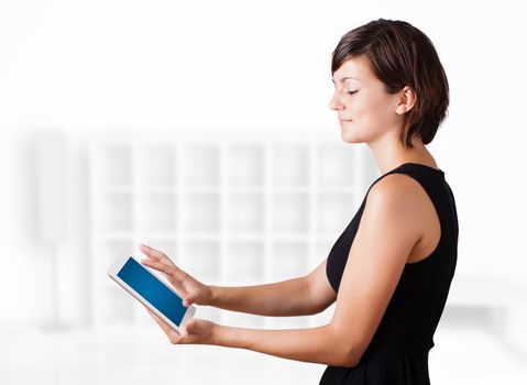 Young business woman looking at modern tablet