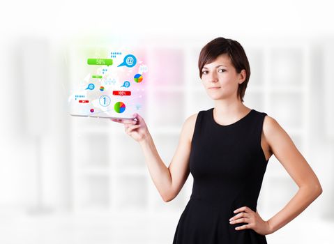 Young business woman looking at modern tablet with colourful technology icons