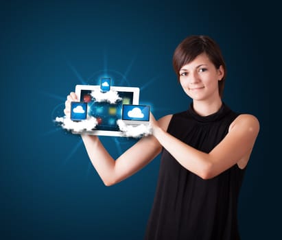 Beautiful young woman holding tablet with modern devices in clouds