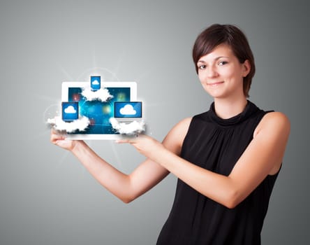 Beautiful young woman holding tablet with modern devices in clouds