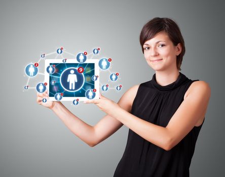 Beautiful young woman holding tablet with social network icons
