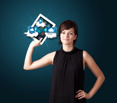 Beautiful young woman holding tablet with modern devices in clouds