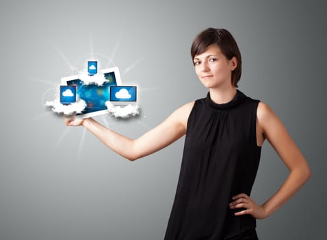 Beautiful young woman holding tablet with modern devices in clouds