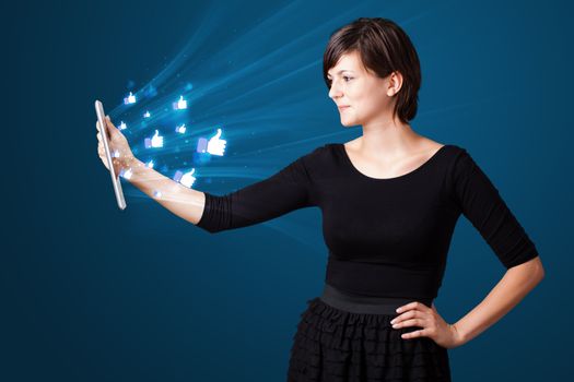 Young business woman looking at modern tablet with abstract lights and social icons