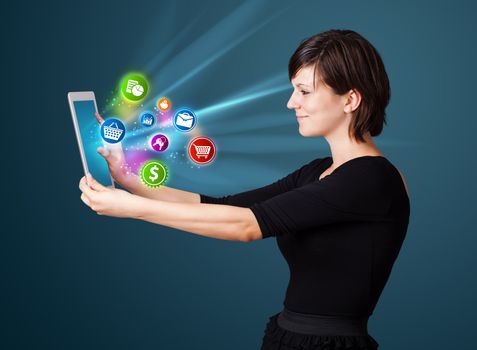 Young business woman looking at modern tablet with abstract lights and various icons