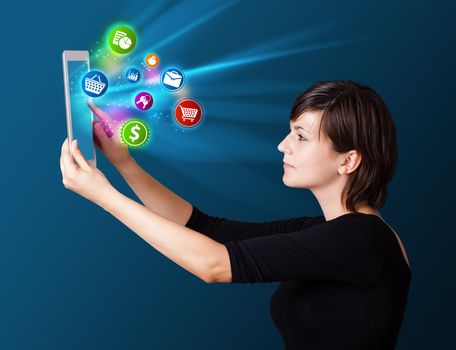 Young business woman looking at modern tablet with abstract lights and various icons